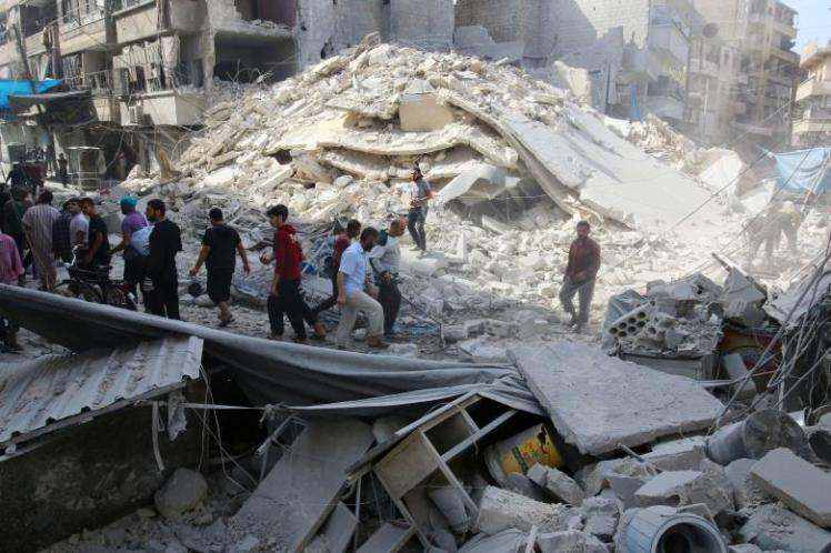 People inspect the damage at a market hit by airstrikes in Aleppo's rebel held al-Fardous district
